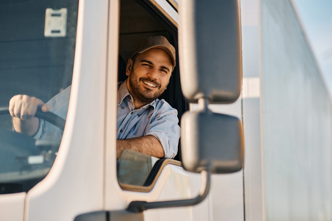 smiling truck driver in cab of semi