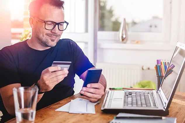 happy man shopping on laptop