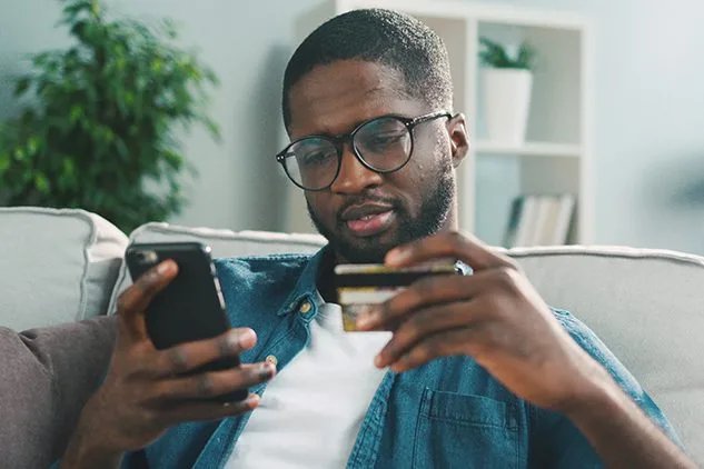 man shopping on phone with credit card out