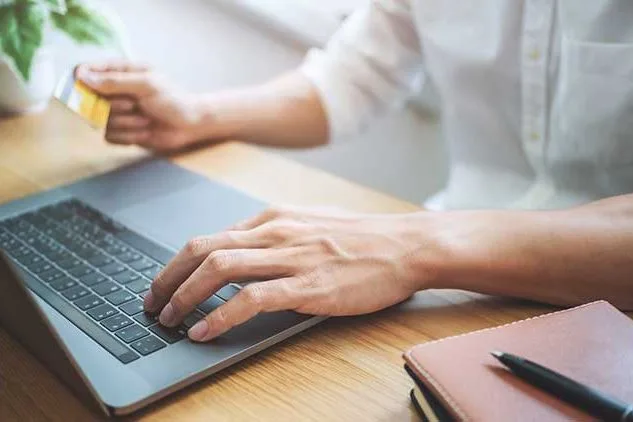 person on computer with credit card