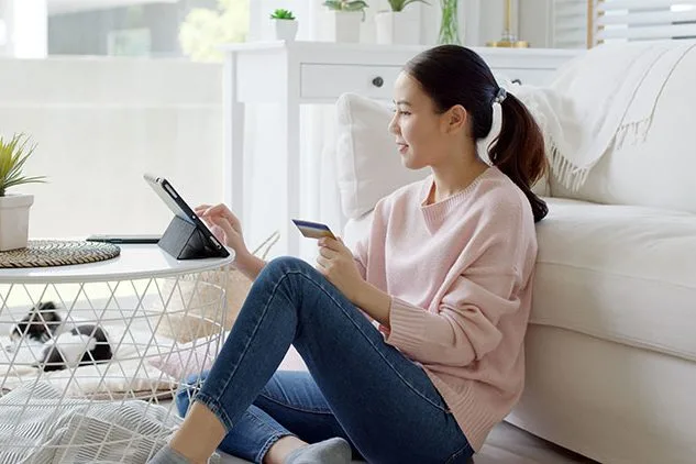 woman shopping on tablet on couch