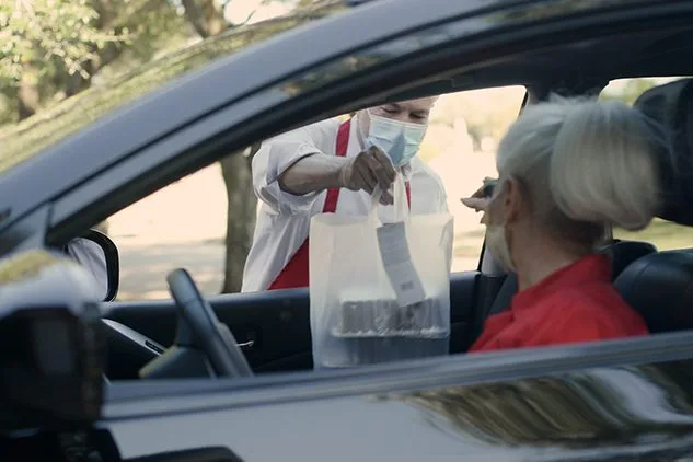 woman picking up package in front of store