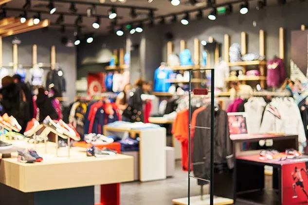 picture of retail clothing store with clothes on racks and shelves