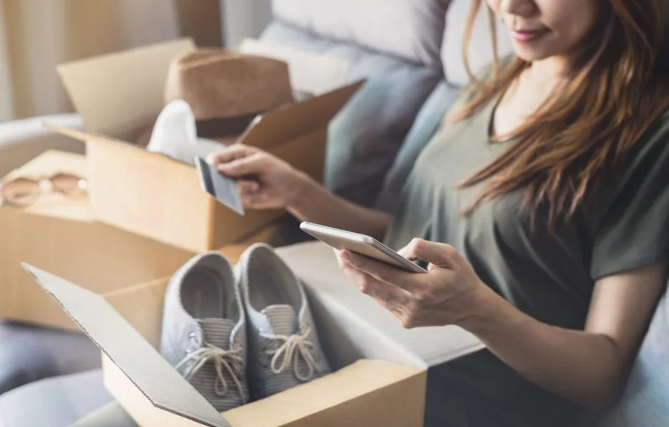 woman opening up package she received with shoes inside