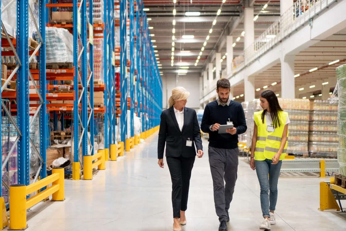 three people walking the floor of a 3pl fulfillment center